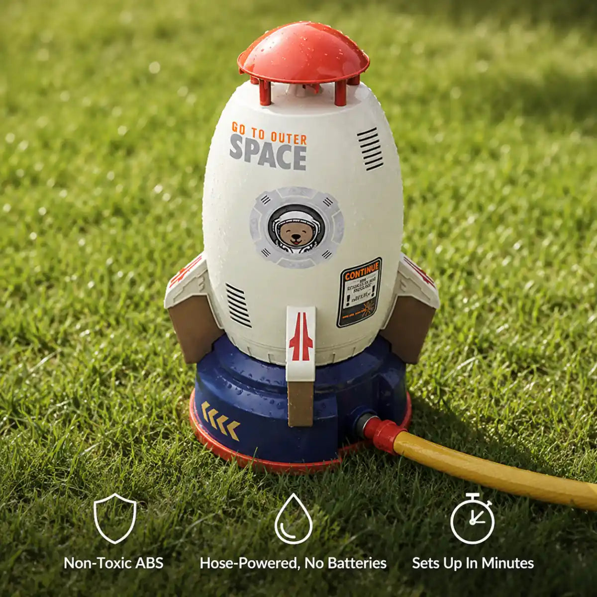 Rocket sprinkler on its launch base with a garden hose attached, showing non-toxic ABS, hose-powered and quick setup features