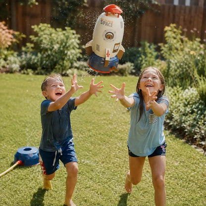 Two kids running with arms outstretched to catch the toy rocket as it falls back down in the garden