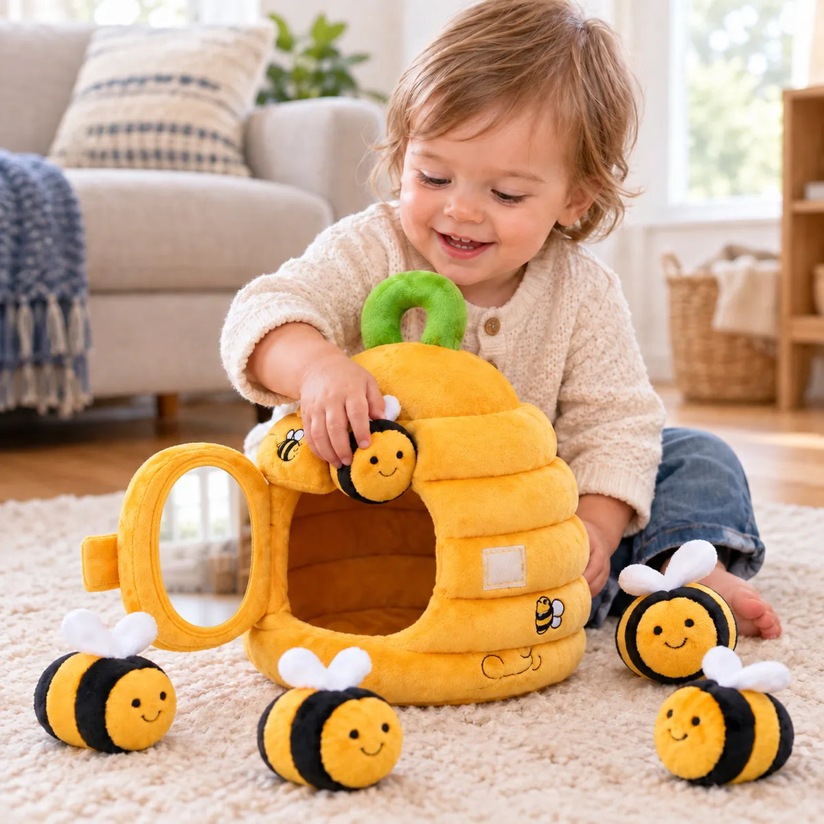 Toddler posting a plush bee into the soft beehive, mirrored door open beside it