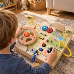 Over the shoulder view of a boy steering the wooden busy dashboard with one hand on the wheel and one on the gear lever