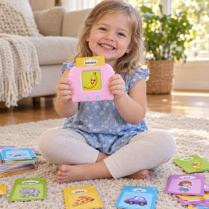 Three-year-old holding up the pink Little Cubs talking flash card reader with a banana card inserted