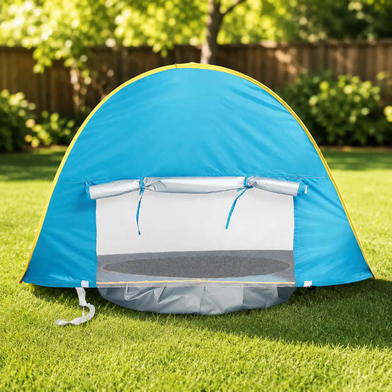 Rear mesh ventilation window and roll-up shade flap of the pop up pool tent set up on grass