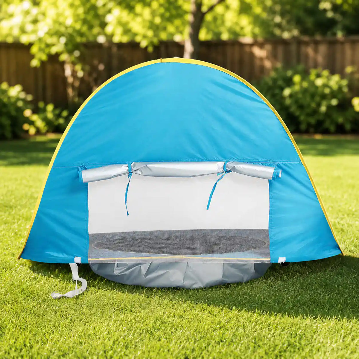 Rear mesh ventilation window and roll-up shade flap of the pop up pool tent set up on grass