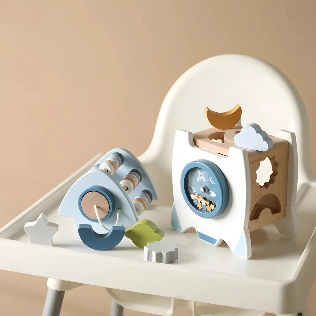 The learning rocket on a high chair tray showing the bead abacus and the shape-sorting face