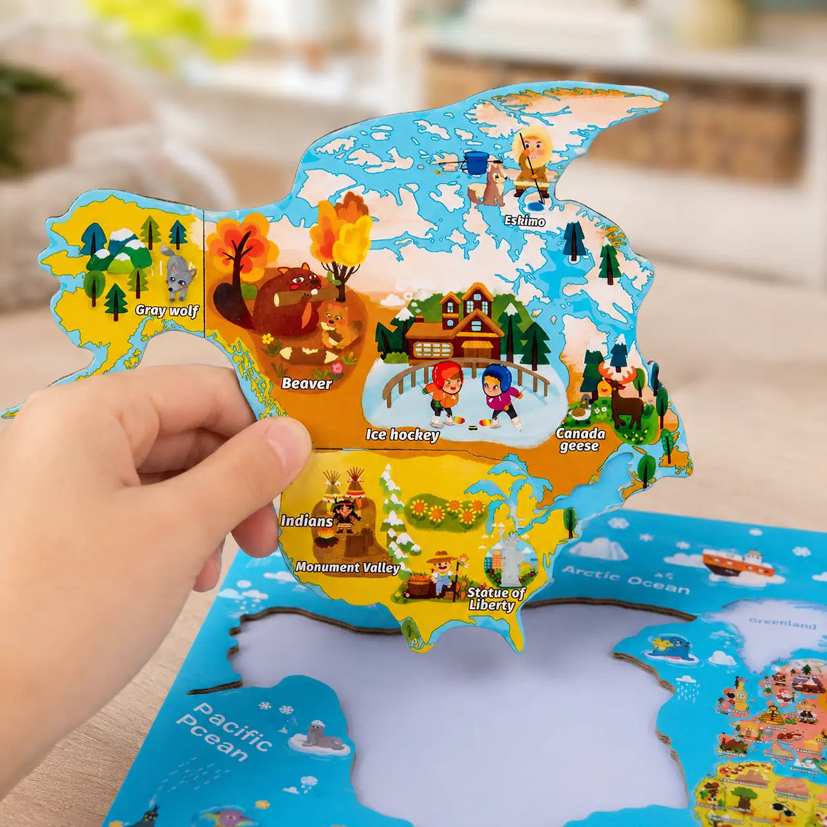 Child's hand lifting the magnetic North America piece clear of the world map board
