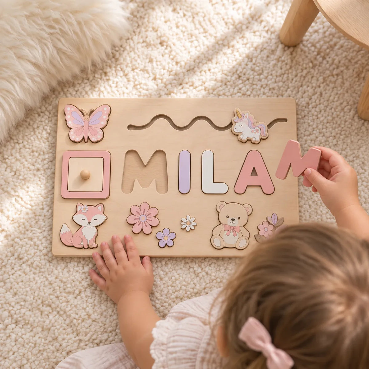 Toddler holding a wooden letter above the empty cut-out in her personalised name puzzle
