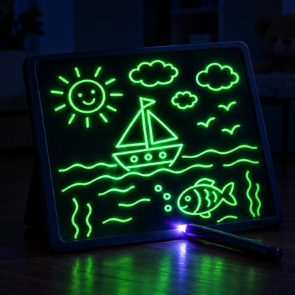 Glow drawing board covered in bright neon green doodles in a dark room with the light pen resting on it