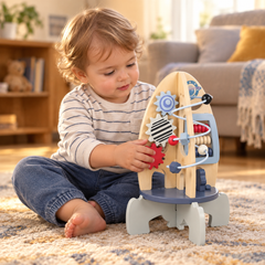 Toddler turning the red gear on the wooden rocket activity centre