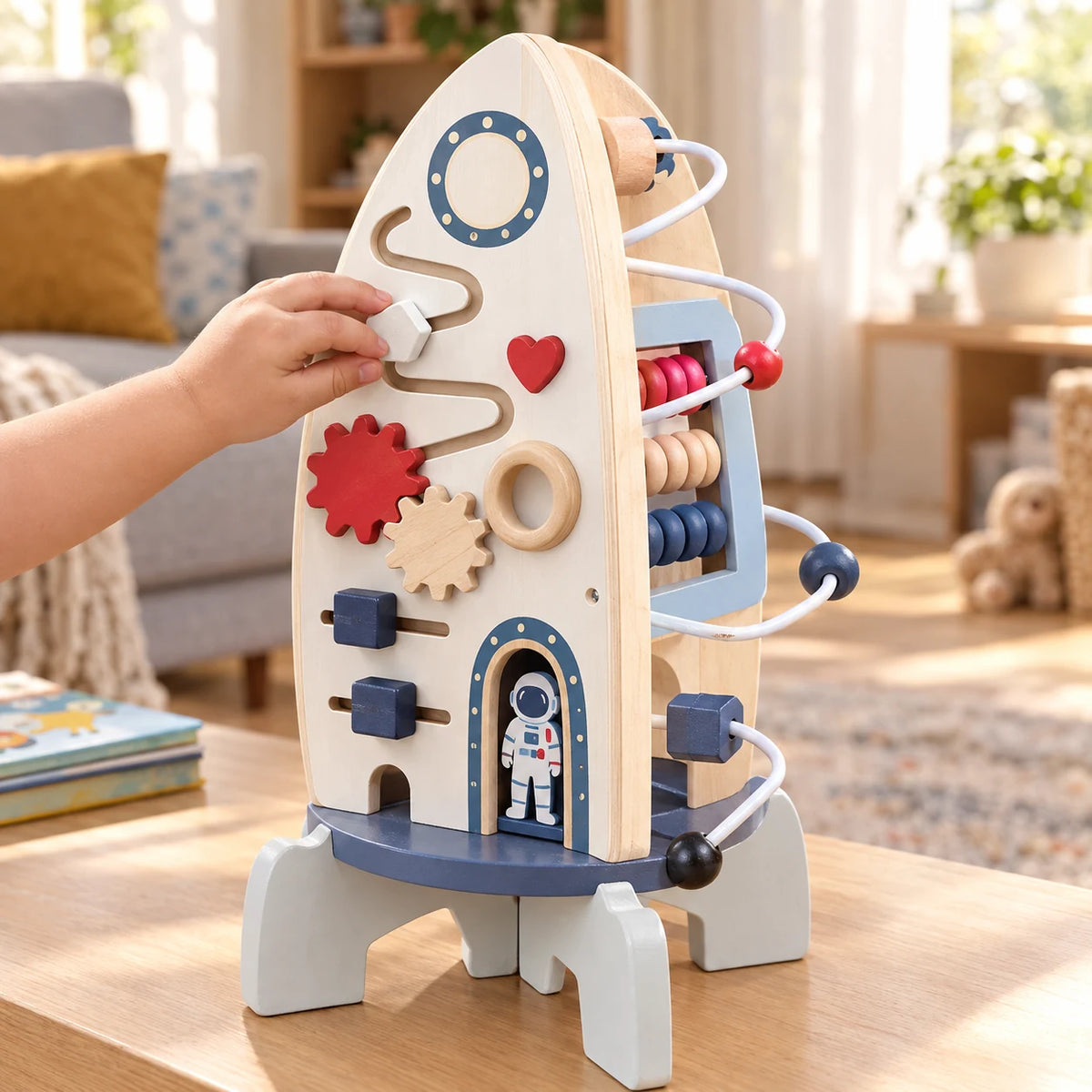Toddler sliding the knob along the groove maze on the other face of the wooden rocket busy board