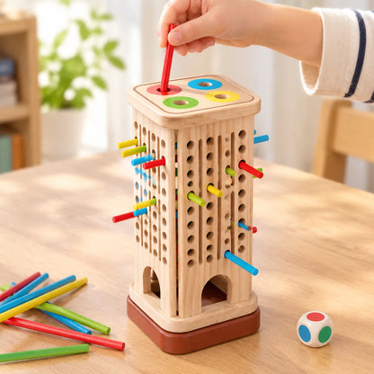 The four-hole colour plate sitting on top of the tower as a lid while a child posts a red stick through the red ring