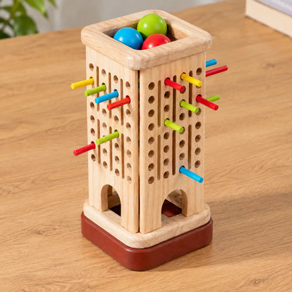 Close-up of the wooden tower showing the drilled hole pattern, coloured sticks and reddish-brown base